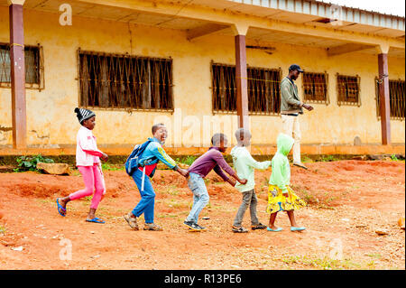 Bafoussam Kamerun - 06. August 2018: junge lächelnde afrikanische Schüler playig und Spaß außerhalb der armen Dorf Schule im Sommer Stockfoto