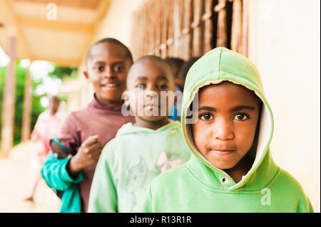 Bafoussam Kamerun - 06. August 2018: close up Portrait von jungen afrikanischen Schule Kind in Kamera mit Lächeln und Freude mit großen Augen suchen Stockfoto