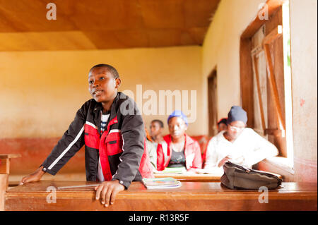 Bafoussam Kamerun - 06. August 2018: lächelndes Kind in Afrika stehen im Klassenzimmer im Gespräch mit Lehrer während der Lektion im Dorf Stockfoto