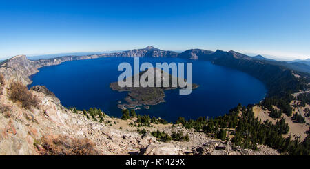 Blick auf den Kratersee und Wizard Island von der Wächter Turm Aussichtspunkt auf einem sonnigen, wolkenlosen Herbst Tag mit nur einem leichten Hauch von Rauch in den Horizont f Stockfoto