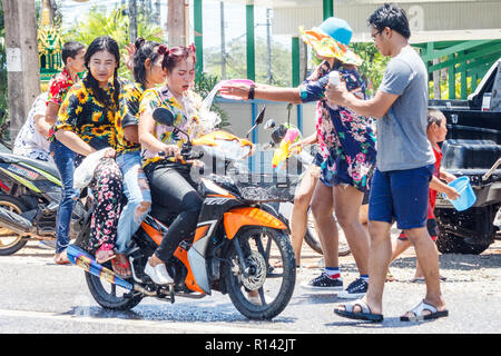 Phuket, Thailand - 13 April 2018: Drei Mädchen auf einem Motorrad mit Wasser besprüht werden. Songkran, das Thailändische Neujahrsfest. Stockfoto