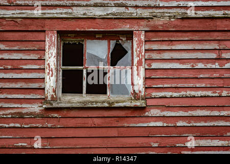 Verwitterte roter Farbe und zerbrochene Fenster sind eine gemeinsame Website auf Scheunen in Vermont. Stockfoto