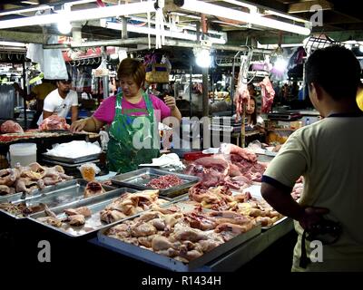 BINANGONAN, Rizal, Philippinen - 8. NOVEMBER 2018: ein Fleisch Anbieter verkauft frisches Fleisch auf einem öffentlichen Markt. Stockfoto