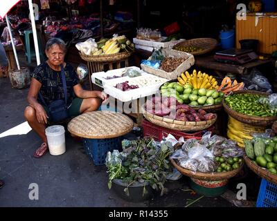 BINANGONAN, Rizal, Philippinen - 8. NOVEMBER 2018: eine Obst- und Gemüse Anbieter verkauft frische Produkte auf einem öffentlichen Markt. Stockfoto