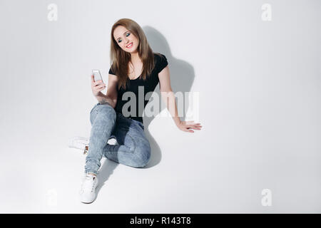 Hübsches Mädchen in schwarzen T-Shirt und Jeans, selfie auf Sitzung Stockfoto