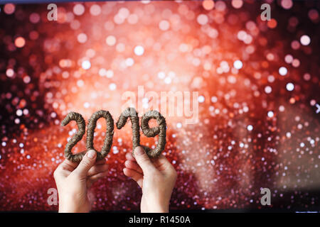 2019 Nummern in den Händen und bokeh Hintergrund. Weihnachten und ein glückliches neues Jahr Konzept Dekor. Stockfoto