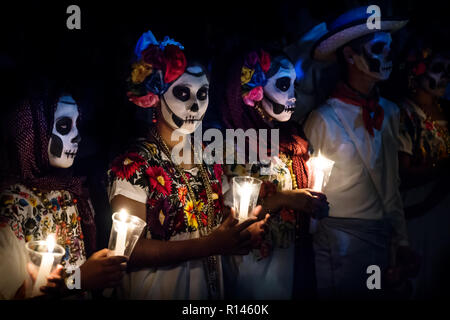 Merida, Cementerio General, Mexiko - 31. Oktober 2018: Die drei Frauen mit Catrina Kunden und Mann mit weissen cowboy Kleid mit skull Make-up Holding kann Stockfoto