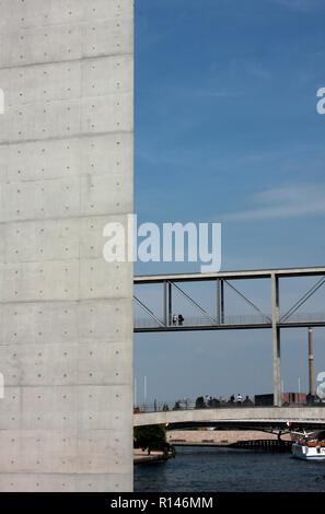 Ein Gehweg entsteht aus einem großen Gebäude aus Beton, wie die Spree fließt unten in Berlin, Deutschland. Stockfoto