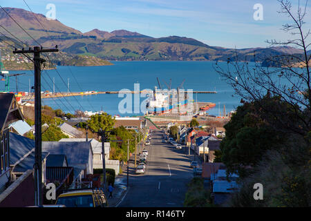 Mit Blick auf den Lyttelton Harbour aus über eine steile Straße in der Stadt Stockfoto