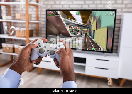 Nahaufnahme einer afrikanischen Mann spielen Spiel mit Joystick im Fernsehen Stockfoto