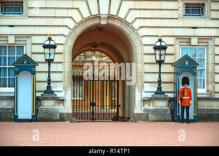 Bewaffnete royal Grenadier guard stand seine Position an eine Sentry Post vor dem Buckingham Palace, auch als Buckingham House bekannt, in der Stadt Stockfoto