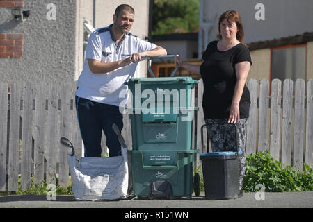 Carl und Cheryl Cox pose mit deren Recycling bins außerhalb ihres Hauses in einer Wohnstraße in Mochdre, Wales, als Conwy Rat eine Regelung t einführen Stockfoto