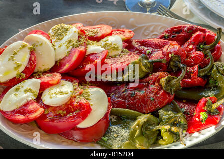 Frischer Salat der Saison. Caprese und geröstete Paprika Salat, gewürzt mit Salz und Olivenöl. Stockfoto