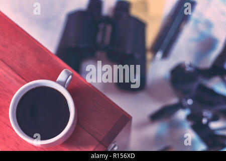 Hintergrund mit Tasse Kaffee und verschwommenes Fernglas, Bleistift, marine Sextant auf Navigationskarte liegen. Stockfoto