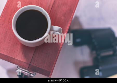 Hintergrund mit Tasse Kaffee und verschwommenes Fernglas, Bleistift, marine Sextant auf Navigationskarte liegen. Stockfoto