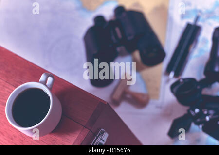 Hintergrund mit Tasse Kaffee und verschwommenes Fernglas, Bleistift, marine Sextant auf Navigationskarte liegen. Stockfoto