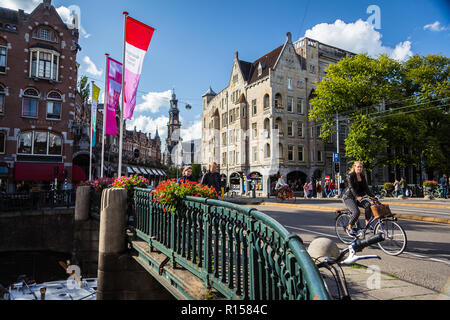 AMSTERDAM, Niederlande - 7 September, 2018: die Frau mit dem Fahrrad auf der Brücke über dem Wasser Kanal in Amsterdam, alte Stadt Stockfoto