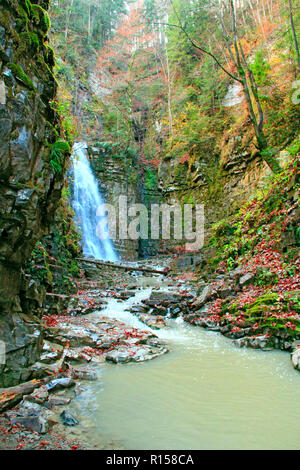 Wasserfall mit Wasser von Klippe. Manyavskii Wasserfall in den Karpaten. Das Wasser fällt von der Klippe. Herbstliche Landschaft in den Bergen mit Stockfoto