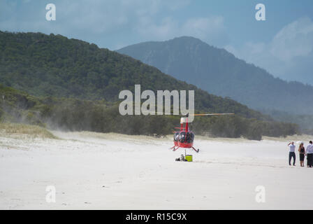 Hubschrauberlandeplatz am Whitehaven Beach, Whitsunday Islands, Queensland, Australien mit blauer Himmel, weißer Sand, blaues Meer und wartende Menschen Stockfoto