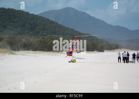 Hubschrauberlandeplatz am Whitehaven Beach, Whitsunday Islands, Queensland, Australien mit blauer Himmel, weißer Sand, blaues Meer und wartende Menschen Stockfoto