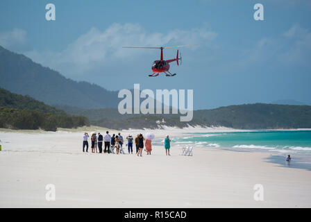 Hubschrauberlandeplatz am Whitehaven Beach, Whitsunday Islands, Queensland, Australien mit blauer Himmel, weißer Sand, blaues Meer und wartende Menschen Stockfoto