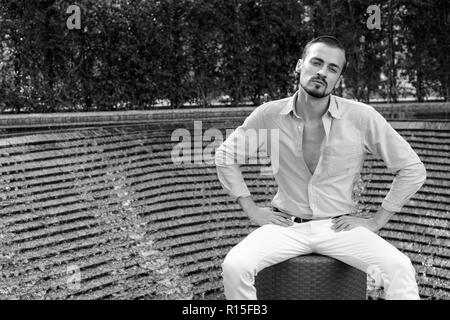 Portrait der junge Bartgeier modische Mann sitzt im Freien Stockfoto