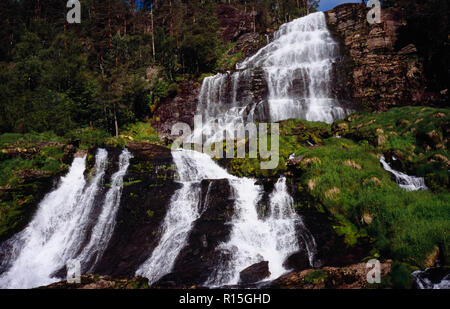 Norwegen, Rogaland, Svandalsfossen, Wasserfall in der Nähe der Stadt Sauda. Abgestufte Ebenen der Felsen mit mehreren Datenströmen weiß Wasser, das von Bäumen und Vegetation umgeben. Stockfoto