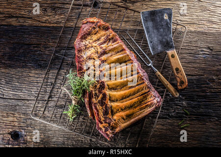 Rohen geräucherten Rippchen und Rosmarin Kräuter auf Holzbrett. Stockfoto