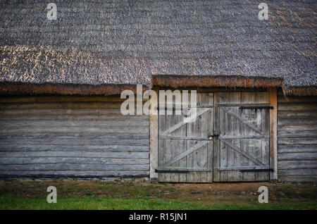 Alte hölzerne Scheune. Anmelden Mauer, Tor und Strohdach. Stockfoto