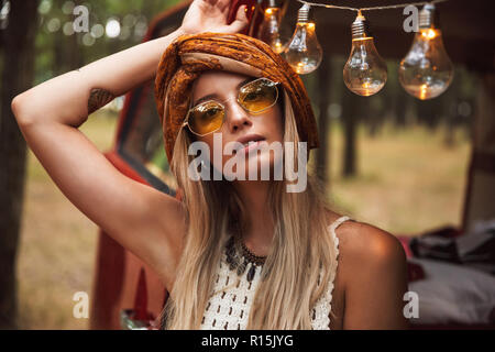 Foto der Schönen hippie Frau mit stilvollen Accessoires, freuen uns, während Er in Forest Camp Stockfoto