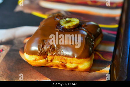 Donut mit Schokolade und Sahne Füllung auf einer Platte. Stockfoto