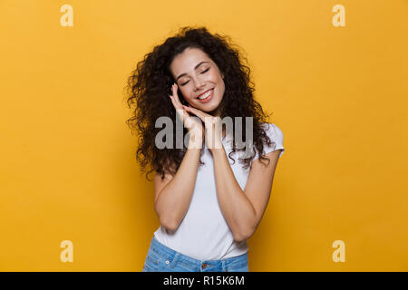 Foto von schönen jungen cute woman auf gelben Hintergrund schlafen isoliert posieren. Stockfoto