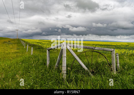 Alten Zaun und Feld gegen einen dramatischen Himmel im südlichen Alberta, Kanada Stockfoto