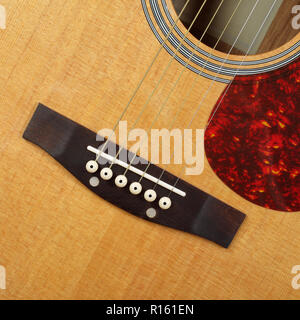 Musikinstrument - Fragment Draufsicht Schlagbrett, Brücke, Stifte und Streichern vintage Akustik Gitarre. Stockfoto