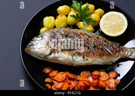 Eine vorzüglich gesunde Mahlzeit: Dorade, sautierten Karotten und gebackene Kartoffeln Stockfoto