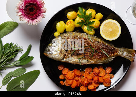 Eine vorzüglich gesunde Mahlzeit: Dorade, sautierten Karotten und gebackene Kartoffeln Stockfoto