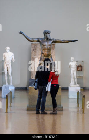 Athen. Griechenland. Besucher im Archäologischen Nationalmuseum von Athen im Artemision Bronze, Statue, Poseidon und Zeus, ancie Stockfoto