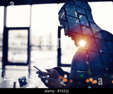 Unternehmer arbeitet mit seinem Smartphone im Büro. Double Exposure Stockfoto