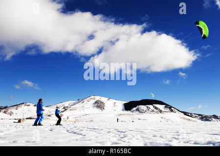 Der Kite snow wirft die Segel zum Wind auf das verschneite Tal Stockfoto