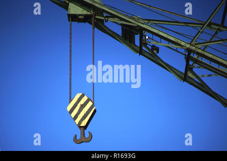 Die massive Kranhaken, der Kran im Hafen vor einem blauen Himmel. Stockfoto