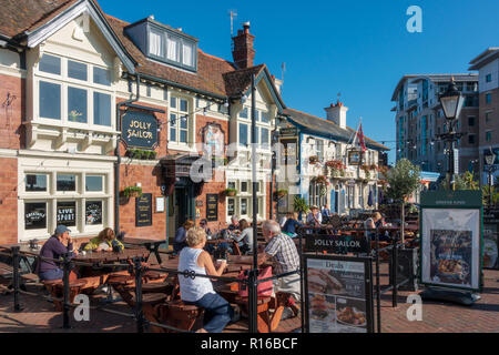 Leute, die vor den Pubs am Meer sitzen, The Jolly Sailor und The Lord Nelson in Poole, Dorset, England Stockfoto