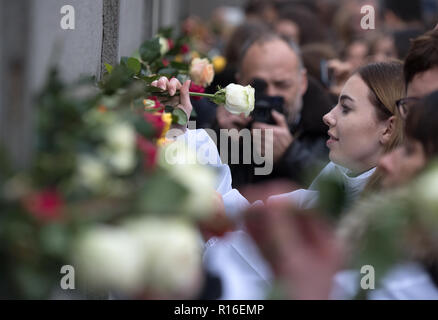 Berlin, Deutschland. 09 Nov, 2018. Teilnehmer an einer Gedenkfeier zum 29. Jahrestag des Falls der Berliner Mauer an der Bernauer Straße Wand denkmal Roses zwischen bleibt der ehemaligen Berliner Mauer stecken. Foto: Ralf Hirschberger/dpa/Alamy leben Nachrichten Stockfoto