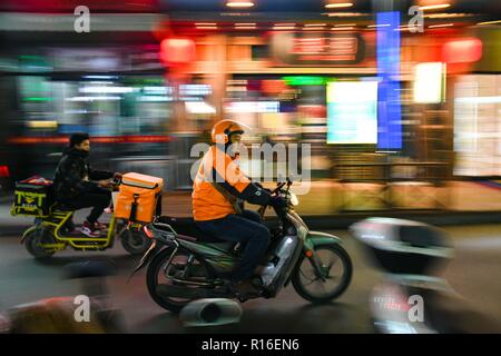 (181109) - jinan, November 9, 2018 (Xinhua) - Hörgeschädigte Lieferung rider Yang Pengpeng dargestellt wird während der Arbeit im Bezirk Kuiwen Weifang, Provinz Shandong im Osten Chinas, November 8, 2018. Eine ausgelagerte Instant Delivery Service Provider in Weifang ist es gelungen, mehr als 30 hörgeschädigte Reiter, die nach relevanten beruflichen Schulungen, bewähren sich genauso kompetent wie ihre Altersgenossen ohne Hörverlust zu beschäftigen. Der hörgeschädigten Delivery Team besteht aus Fahrern aus unterschiedlichen Hintergründen: Hochschulabsolvent, alleinerziehende Mutter, ehemaliger fahren Bus und andere. Und die r Stockfoto