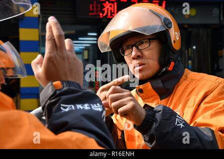 (181109) - jinan, November 9, 2018 (Xinhua) - Hörgeschädigte Lieferung rider Wang Shulin kommuniziert mit einer Verwendung von Gebärdensprache in der Kuiwen Stadtbezirk der bezirksfreien Stadt Kollege, der ostchinesischen Provinz Shandong, November 8, 2018. Eine ausgelagerte Instant Delivery Service Provider in Weifang ist es gelungen, mehr als 30 hörgeschädigte Reiter, die nach relevanten beruflichen Schulungen, bewähren sich genauso kompetent wie ihre Altersgenossen ohne Hörverlust zu beschäftigen. Der hörgeschädigten Delivery Team besteht aus Fahrern aus unterschiedlichen Hintergründen: Hochschulabsolvent, alleinerziehende Mutter, ehemaliger fahren Coa Stockfoto