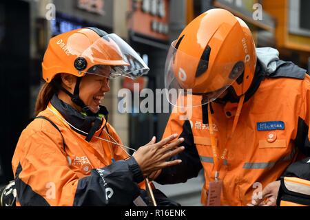 (181109) - jinan, November 9, 2018 (Xinhua) - Hörgeschädigte Lieferung rider Gao Li (L) kommuniziert mit einem mit Gebärdensprache in Kuiwen Stadtbezirk der bezirksfreien Stadt Kollege, der ostchinesischen Provinz Shandong, November 8, 2018. Eine ausgelagerte Instant Delivery Service Provider in Weifang ist es gelungen, mehr als 30 hörgeschädigte Reiter, die nach relevanten beruflichen Schulungen, bewähren sich genauso kompetent wie ihre Altersgenossen ohne Hörverlust zu beschäftigen. Der hörgeschädigten Delivery Team besteht aus Fahrern aus unterschiedlichen Hintergründen: Hochschulabsolvent, alleinerziehende Mutter, ehemaliger Fahren coac Stockfoto