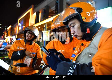 (181109) - jinan, November 9, 2018 (Xinhua) - Hörgeschädigte Lieferung rider Yang Pengpeng (1. R) kommuniziert mit einem mit Gebärdensprache in Kuiwen Stadtbezirk der bezirksfreien Stadt Kollege, der ostchinesischen Provinz Shandong, November 8, 2018. Eine ausgelagerte Instant Delivery Service Provider in Weifang ist es gelungen, mehr als 30 hörgeschädigte Reiter, die nach relevanten beruflichen Schulungen, bewähren sich genauso kompetent wie ihre Altersgenossen ohne Hörverlust zu beschäftigen. Der hörgeschädigten Delivery Team besteht aus Fahrern aus unterschiedlichen Hintergründen: Hochschulabsolvent, alleinerziehende Mutter, ehemaligen d Stockfoto