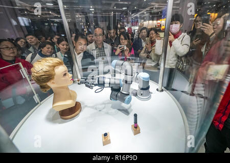 Shanghai, China. 9 Nov, 2018. Besucher sehen ein Roboterarm mit Make-up-Phobie bei der Bekleidung, Accessoires & Konsumgüter bereich der ersten China International Import Expo (CIIE) in Shanghai, China, November 9, 2018. Credit: Shen Bohan/Xinhua/Alamy leben Nachrichten Stockfoto