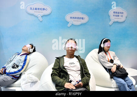 Shanghai, China. 9 Nov, 2018. Besucher versuchen selbst - Erwärmung Dampf augenmasken an der Bekleidung, Accessoires & Konsumgüter bereich der ersten China International Import Expo (CIIE) in Shanghai, China, November 9, 2018. Credit: Lin Xin/Xinhua/Alamy leben Nachrichten Stockfoto
