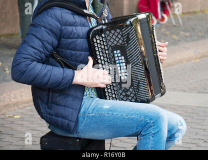 Männliche Musiker spielen auf Akkordeon auf der Straße. Stockfoto