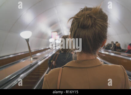 Frau mit einer Rolltreppe in der Metro. Stockfoto